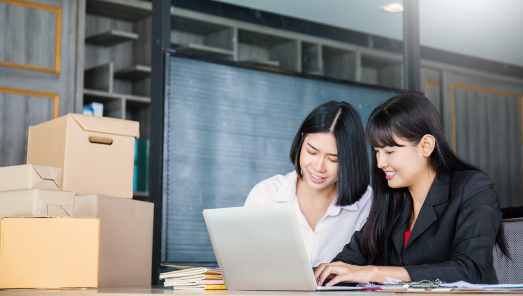 Two women doing training on a computer. Training is an important part of Change Management.