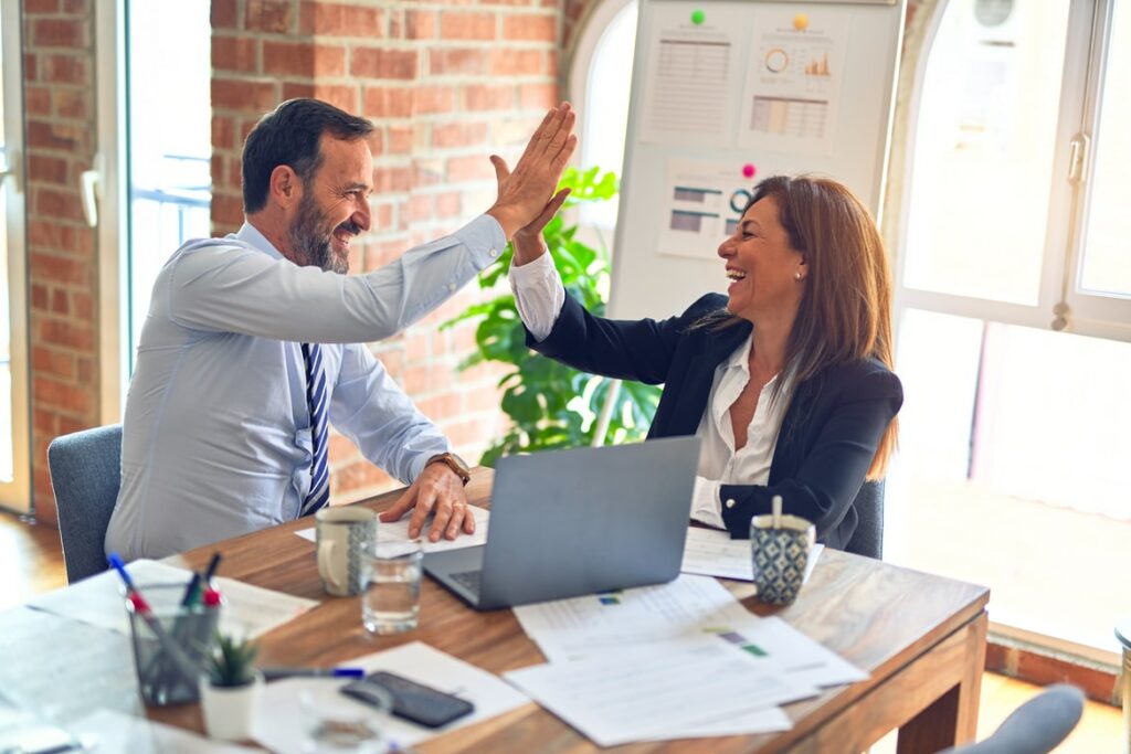 man and woman high-fiving at table