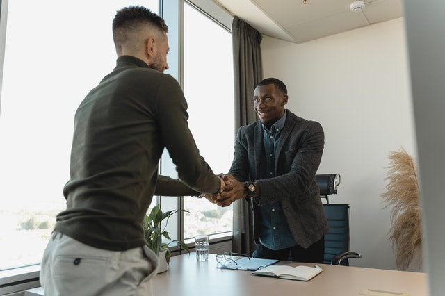 two men shaking hands in office